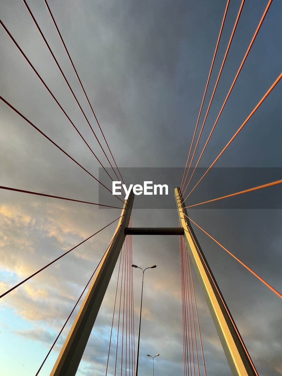 architecture, sky, line, transportation, built structure, bridge, cloud, light, nature, city, reflection, no people, cable-stayed bridge, suspension bridge, sunlight, outdoors, mode of transportation, travel, cable, building exterior, water, mast, travel destinations, motion