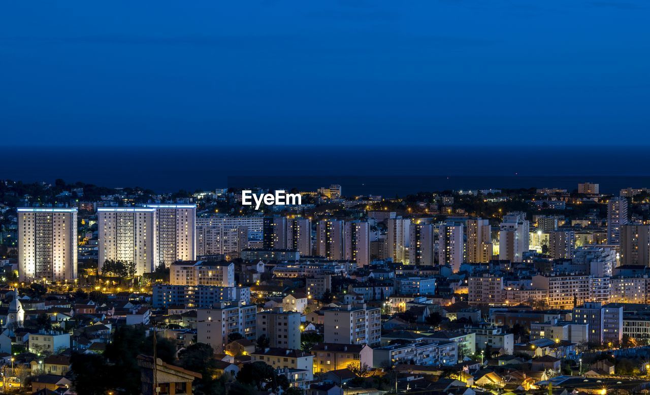 High angle view of city lit up at night