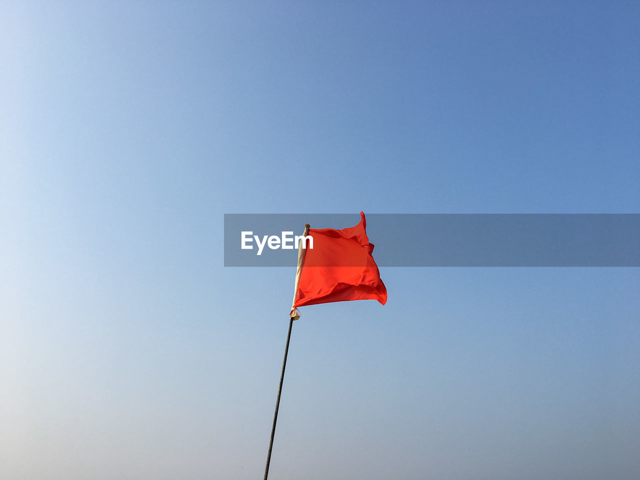 flag, red, sky, patriotism, nature, environment, wind, blue, clear sky, no people, copy space, day, toy, sunny, red flag, outdoors, low angle view, pole, emotion