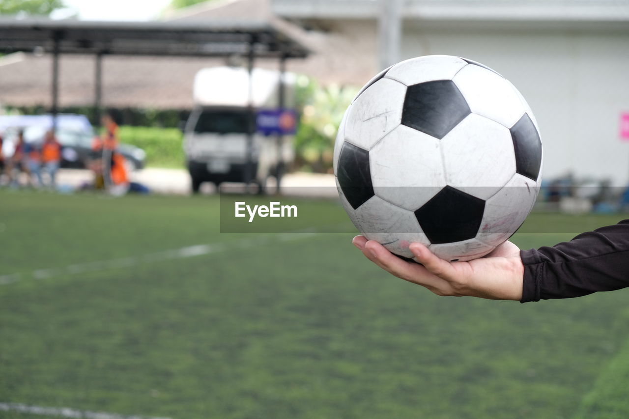 Cropped hand holding soccer ball