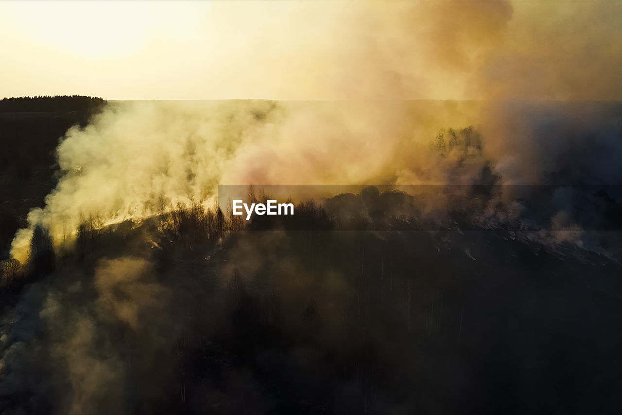 SMOKE EMITTING FROM CLOUDS AGAINST SKY