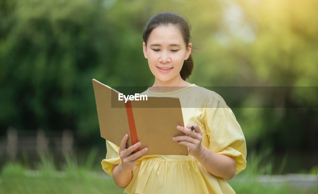 YOUNG WOMAN HOLDING BOOK