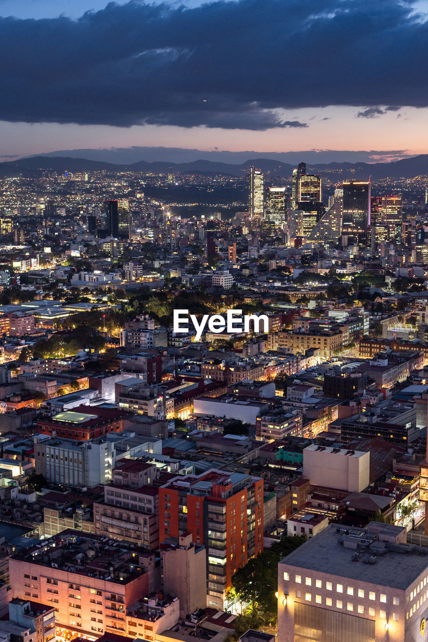 Aerial view of illuminated cityscape against sky at night