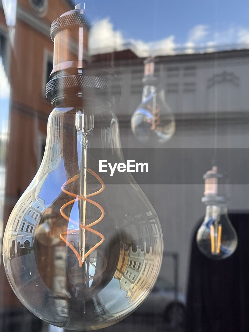 Close-up of light bulb and reflection of houses 