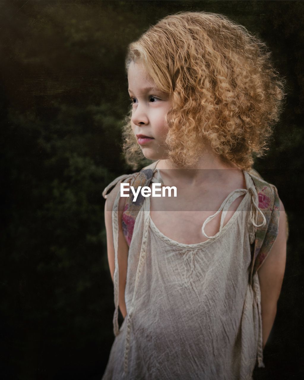 Close-up of cute girl with curly hair looking away