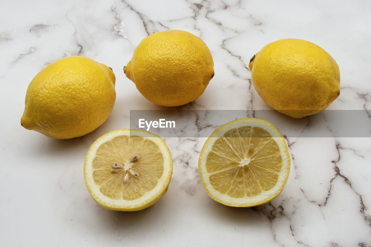 Fresh lemons isolated on clear marble background