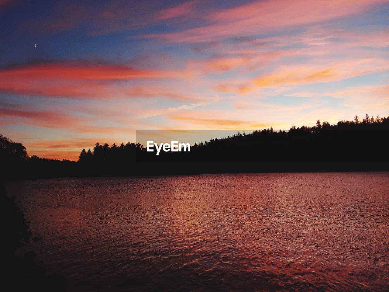 Scenic view of lake against orange sky