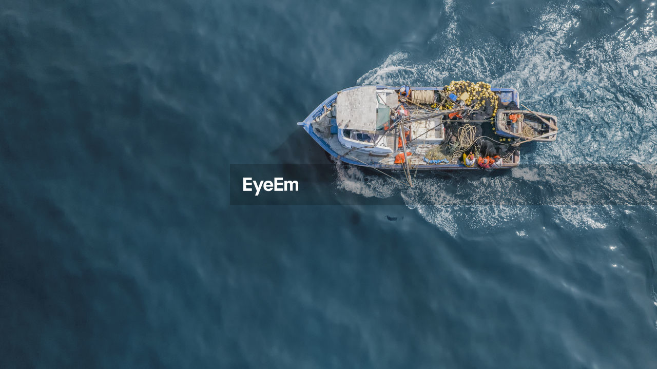 HIGH ANGLE VIEW OF SHIP SAILING ON SEA