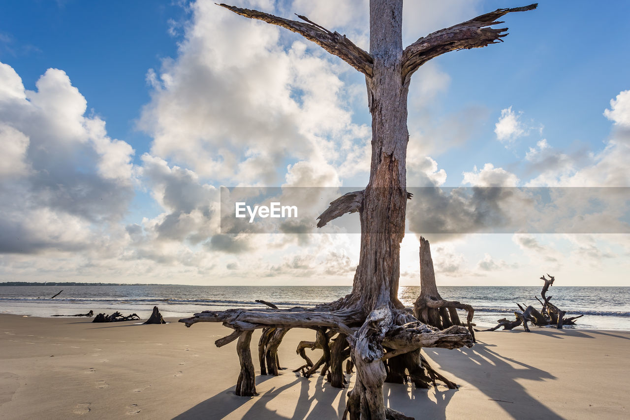 Metallic structure on beach against sky