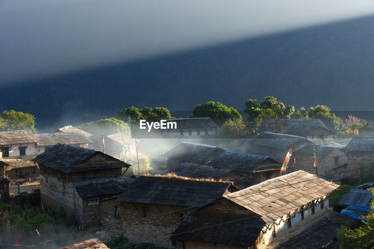 High angle view of ancient buildings against sky with sunbeam at morning