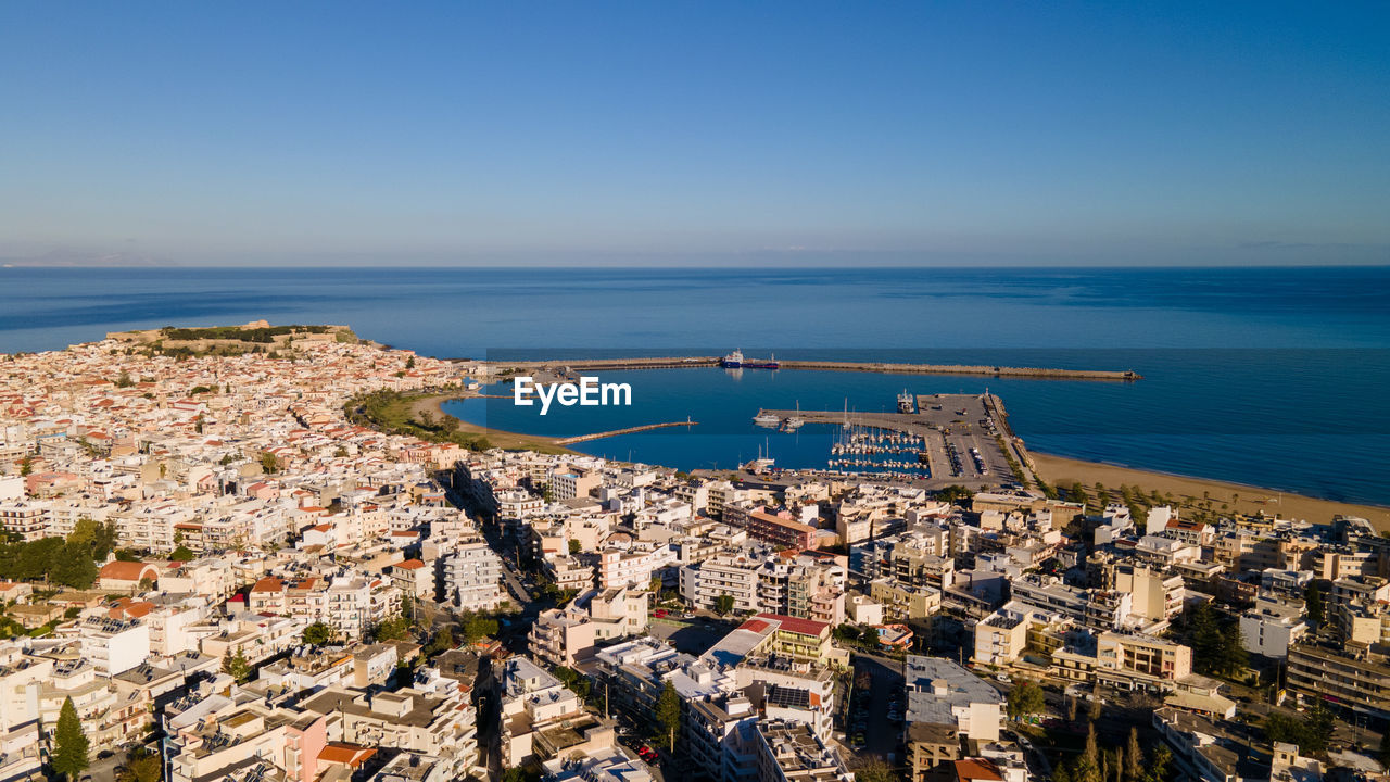 High angle view of city rethymno in crete, by sea against clear sky