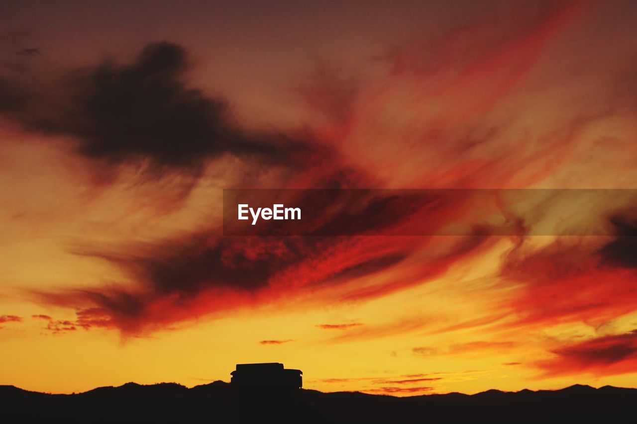 LOW ANGLE VIEW OF DRAMATIC SKY OVER SILHOUETTE LANDSCAPE