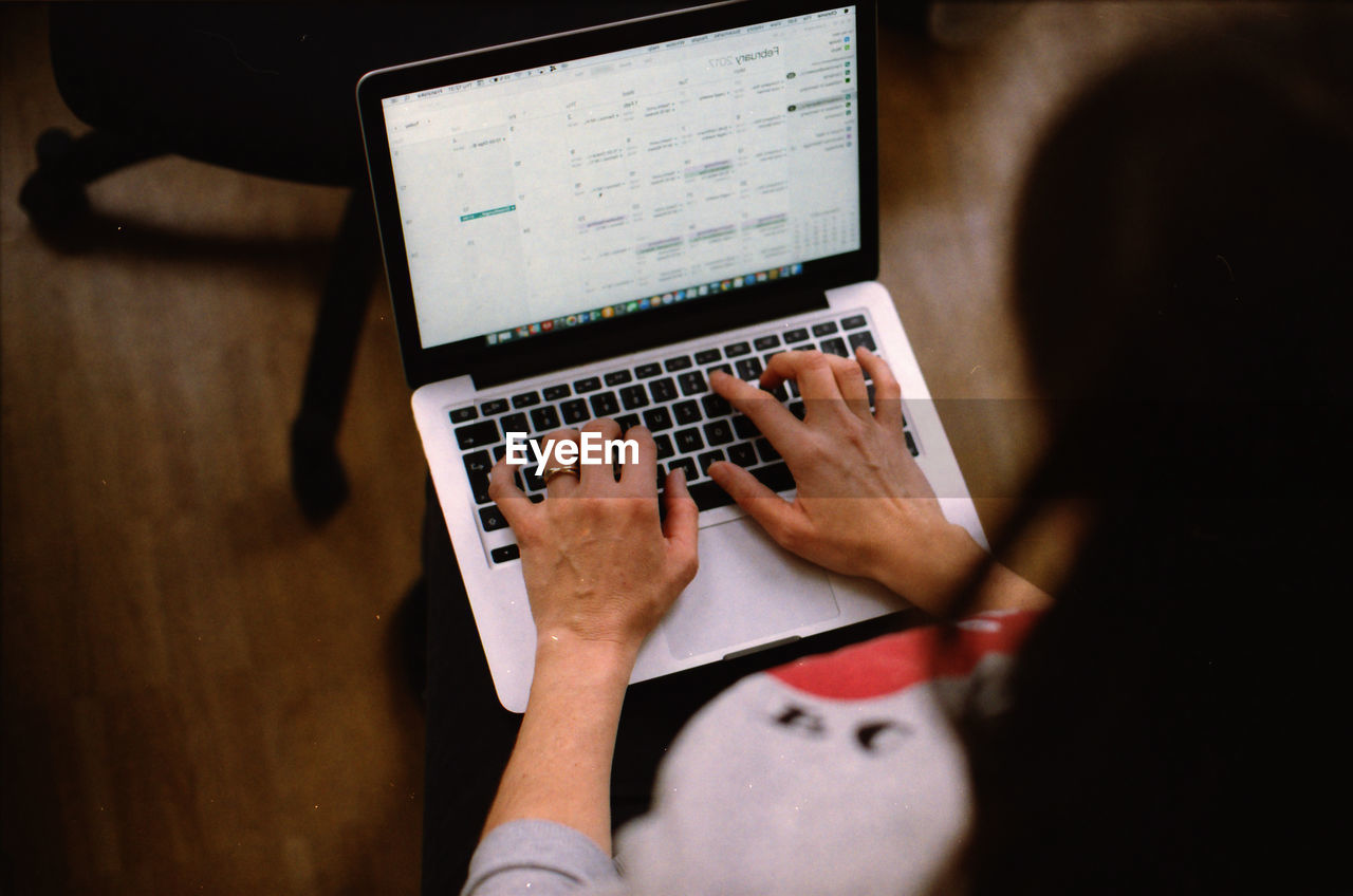 Close-up of woman using laptop at home