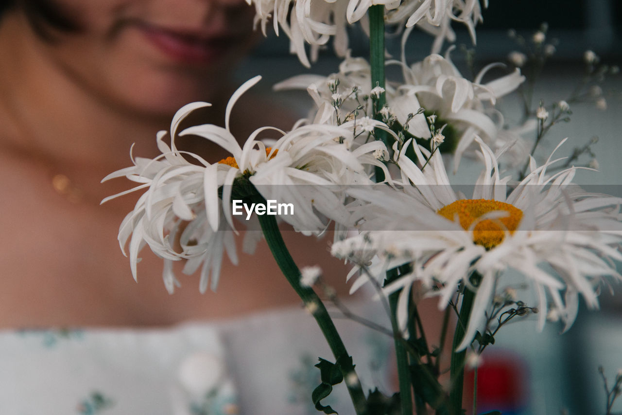 Close-up of woman by white flowers 