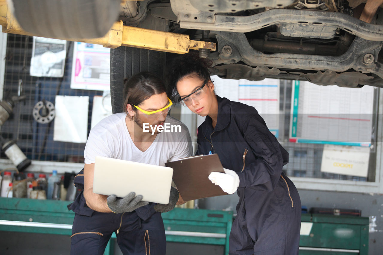 Young mechanics working at garage