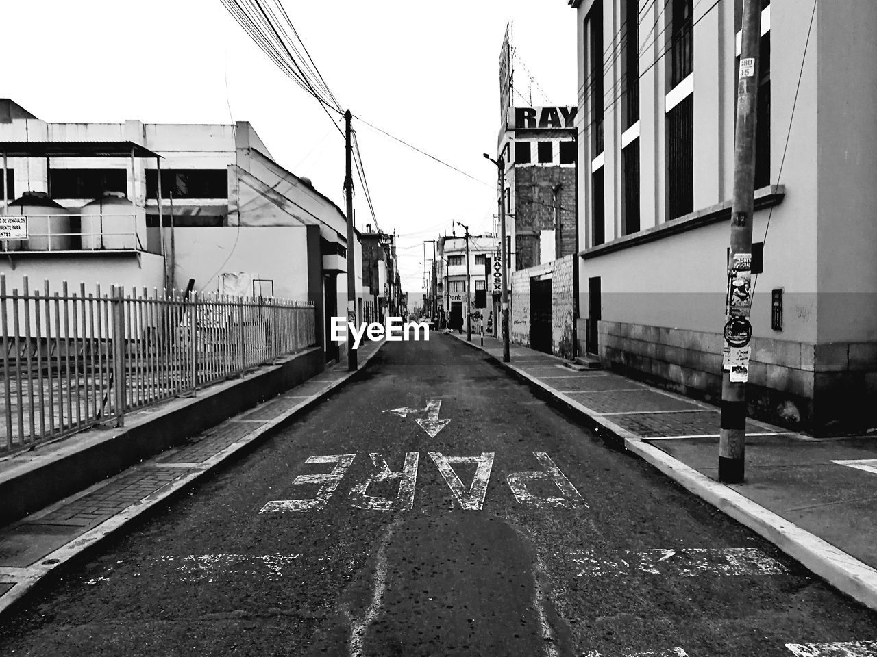 Road sign on street in city against sky