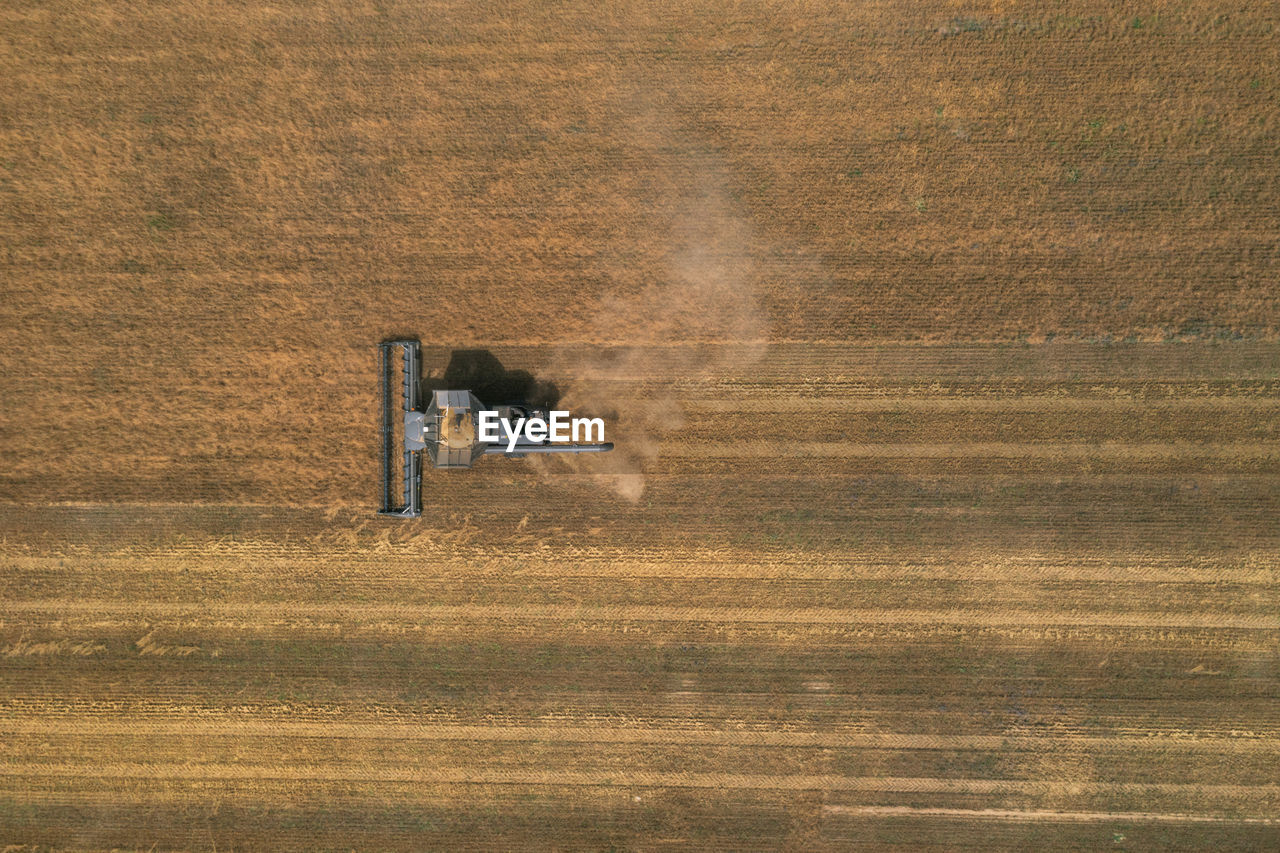 New black harvester on the wheat field from the top view. harvest time.