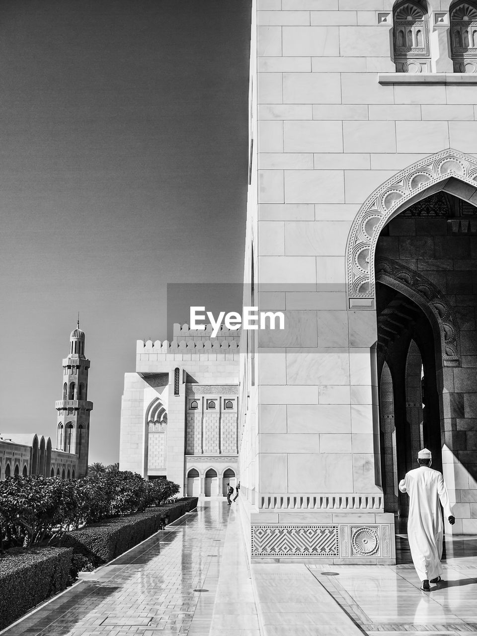 Full length rear view of man visiting mosque against clear sky