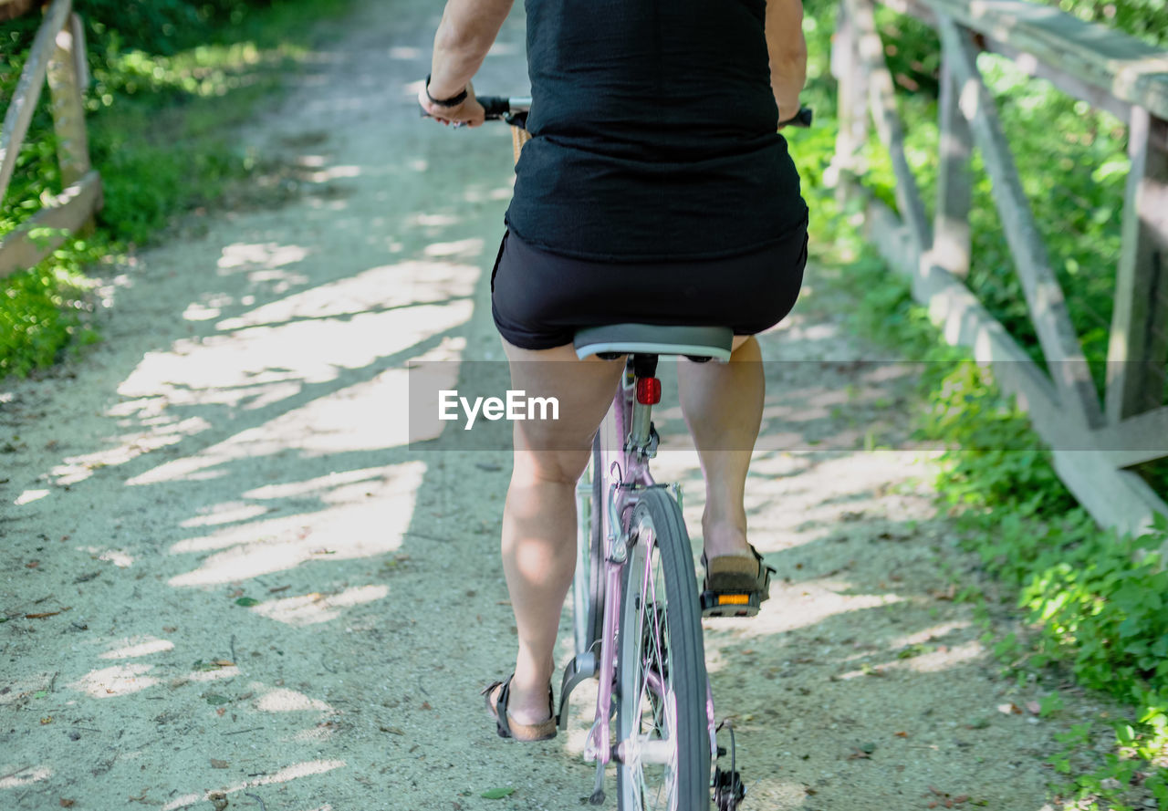 LOW SECTION OF WOMAN RIDING BICYCLE