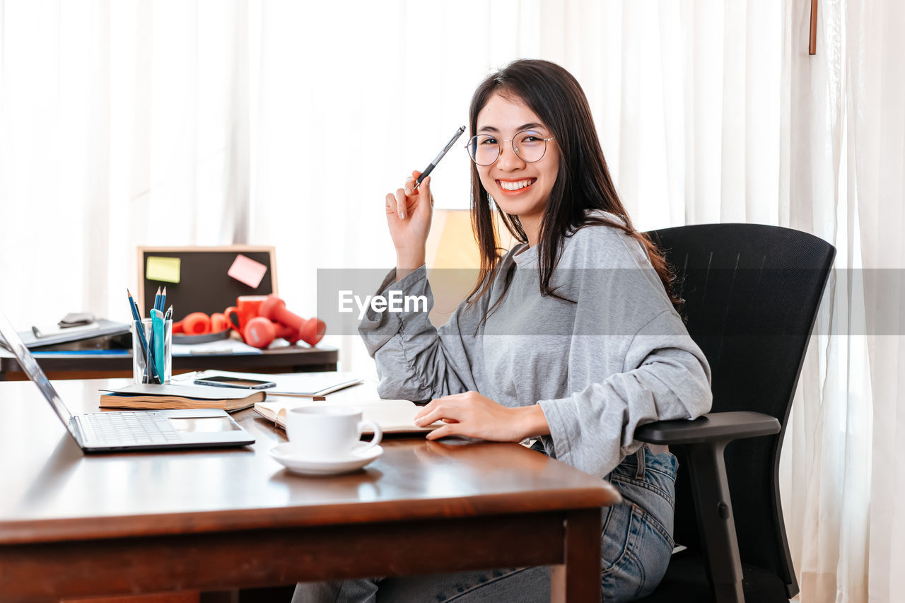Smiling businesswoman sitting at desk in office