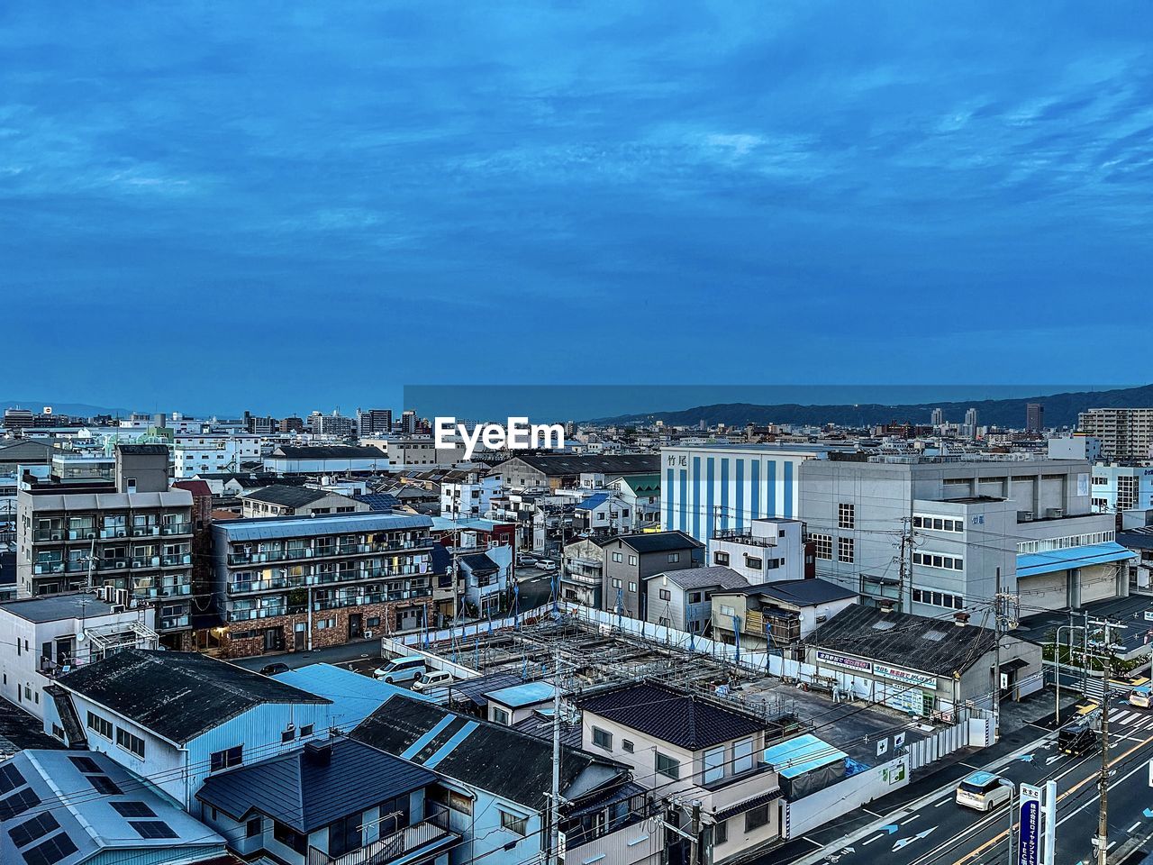 High angle view of city buildings against blue sky