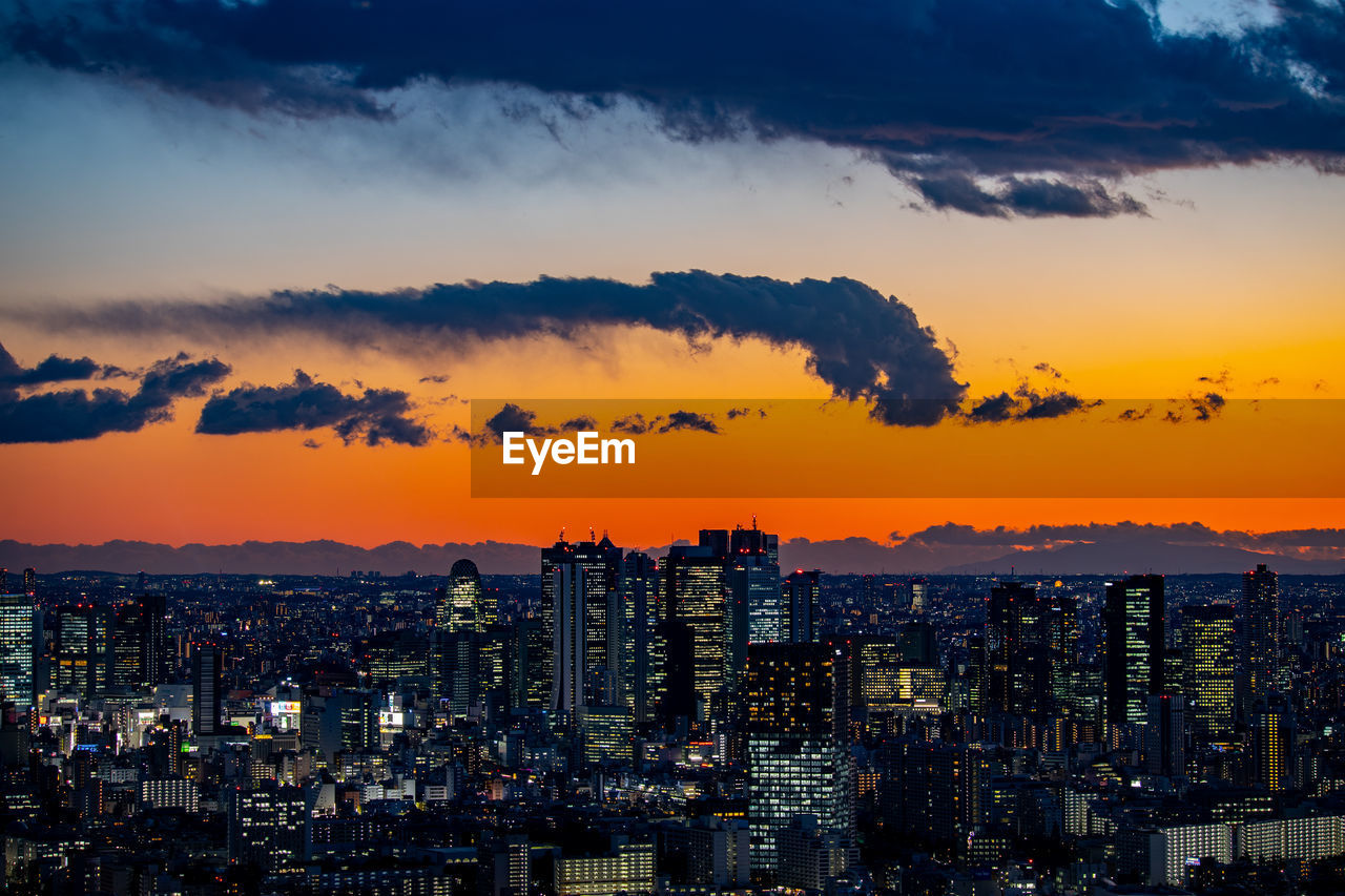 High angle view of modern buildings against sky during sunset