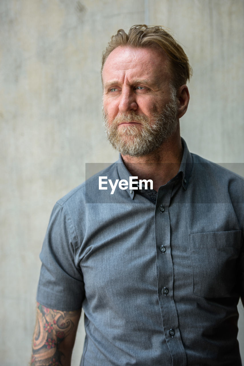 Portrait of man standing against wall