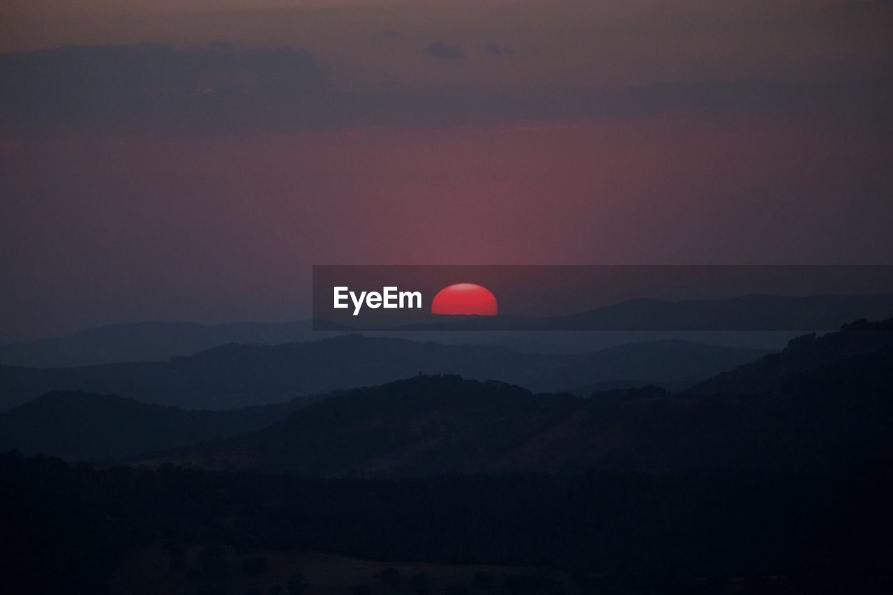 Scenic view of silhouette mountains against sky at sunset