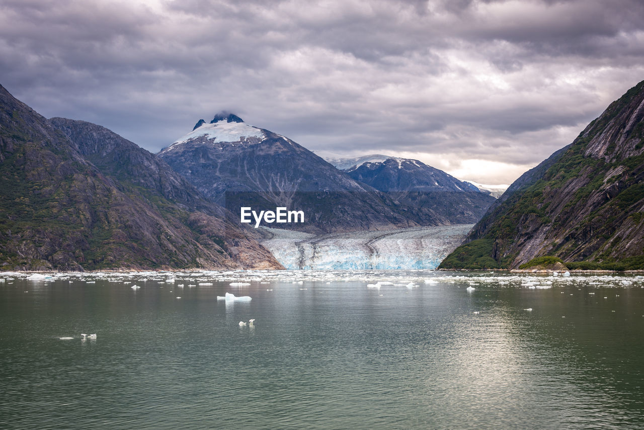 Scenic view of lake by mountains against sky