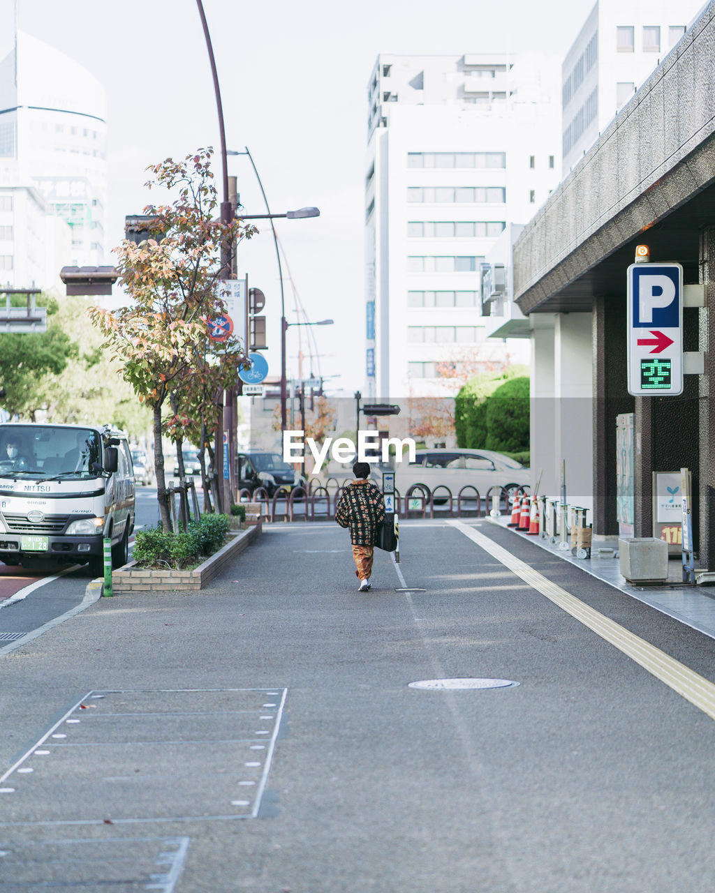 REAR VIEW OF MAN ON STREET