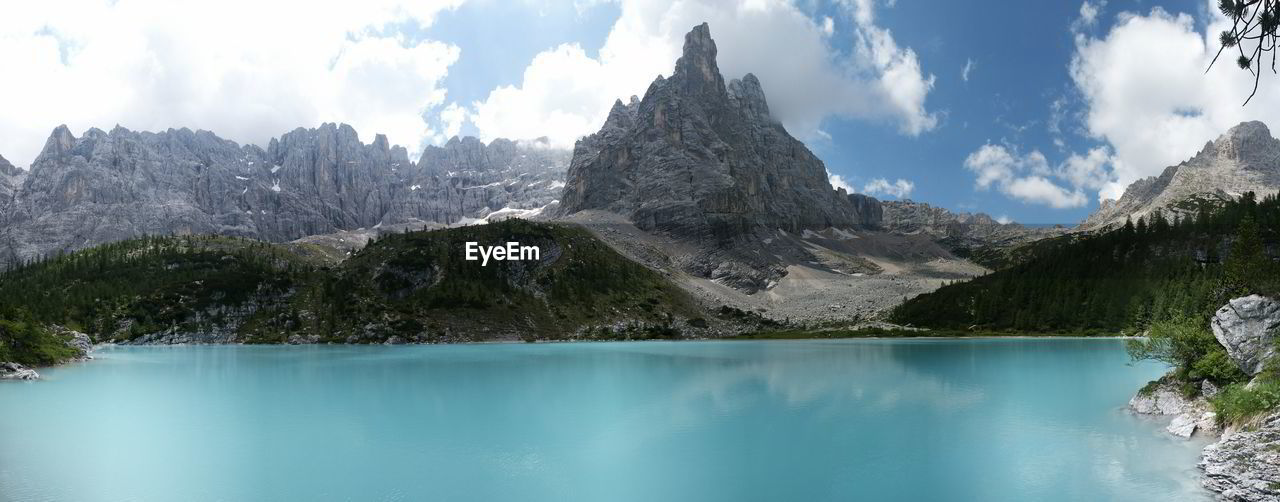 Scenic view of lake and mountains against cloudy sky