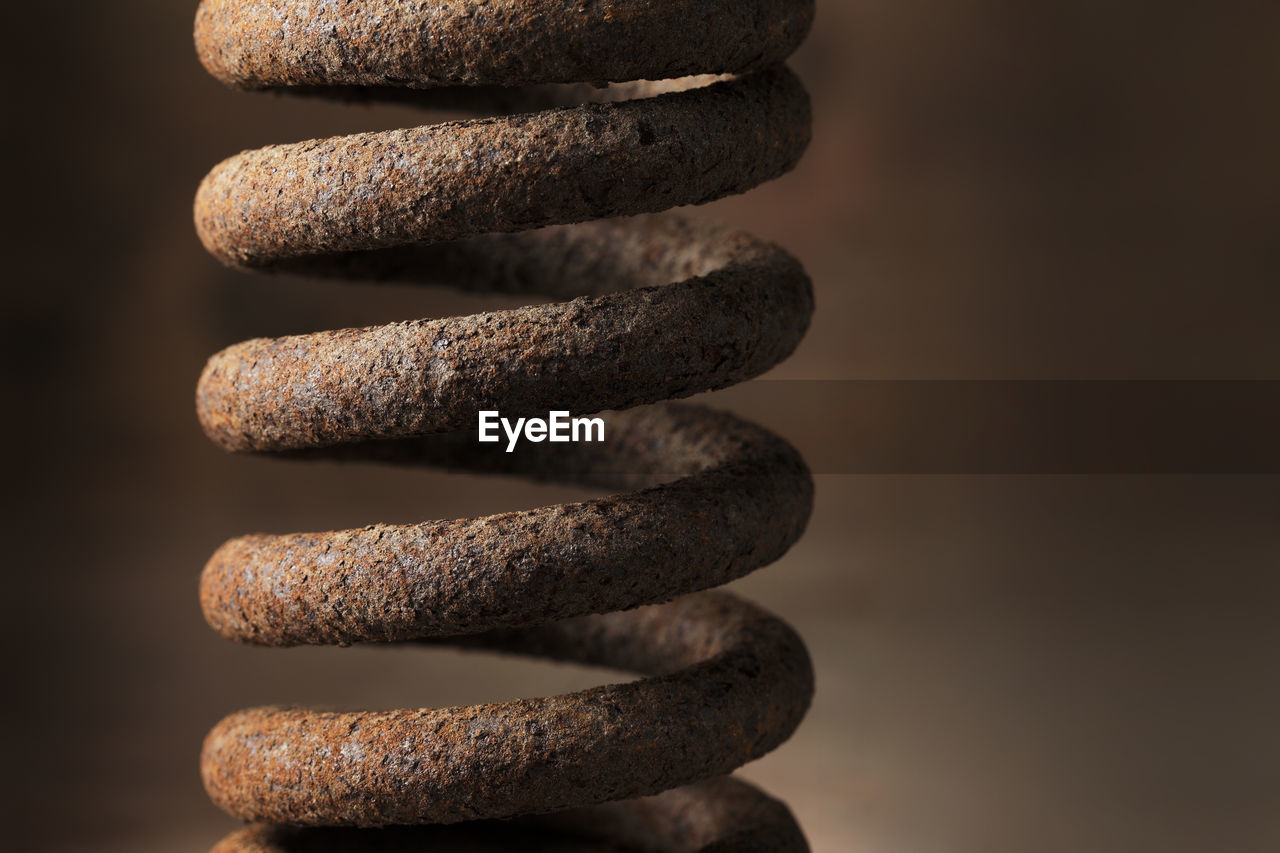 Close-up of rusty spiral metal against blurred background