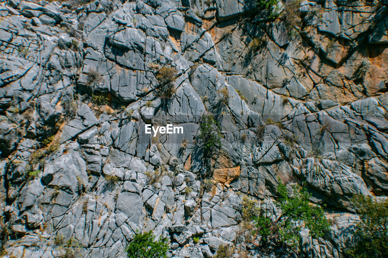 HIGH ANGLE VIEW OF ROCK ON FIELD