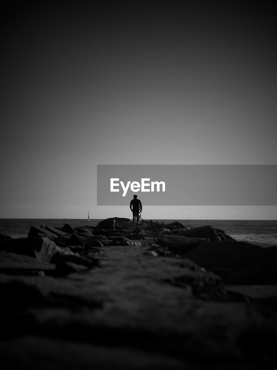 SIDE VIEW OF MAN STANDING ON BEACH