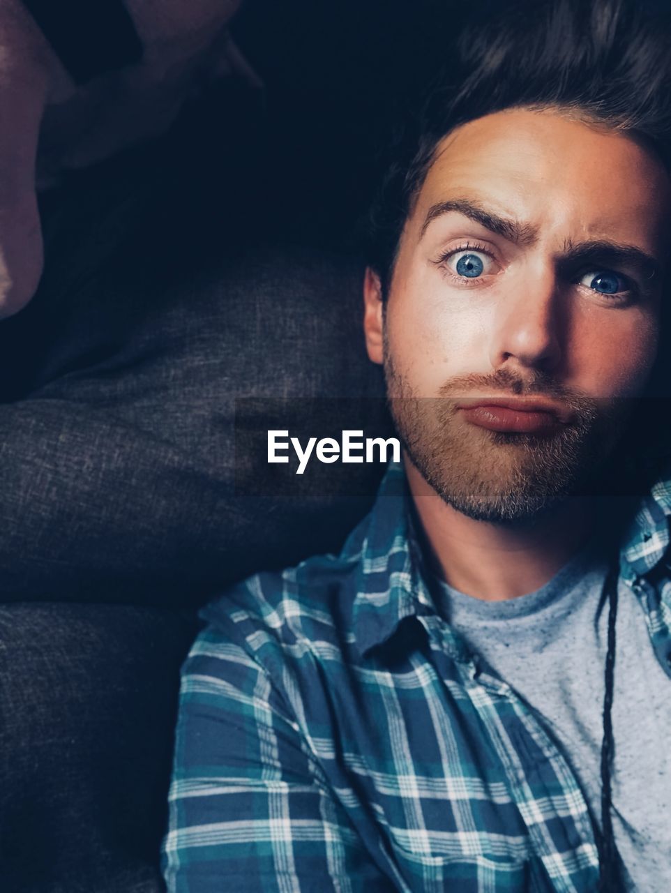 Close-up portrait of young man making face at home