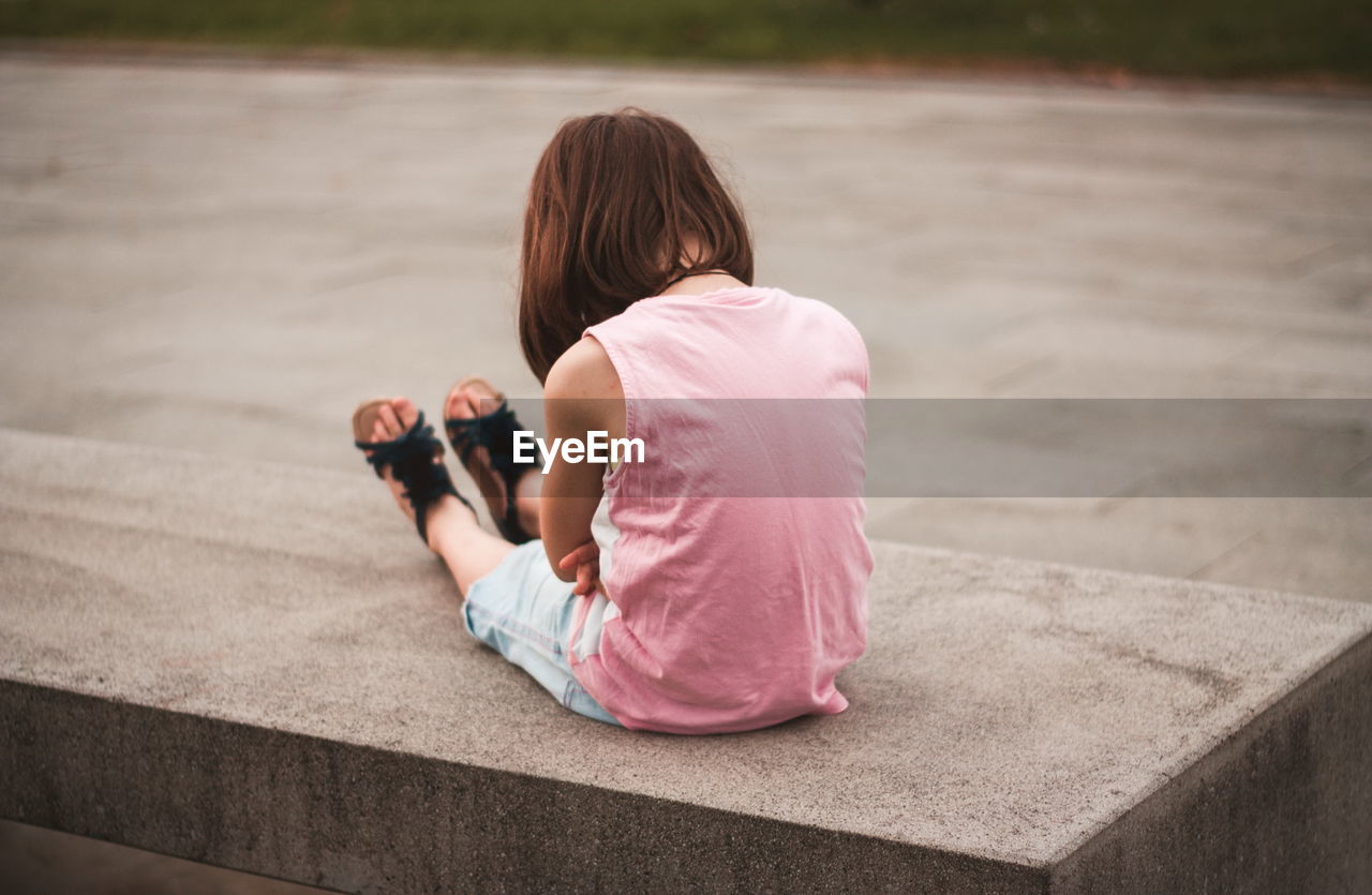 Little girl sitting alone on the bench