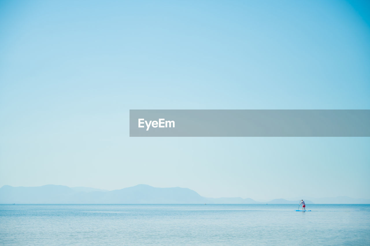 SAILBOATS IN SEA AGAINST CLEAR SKY