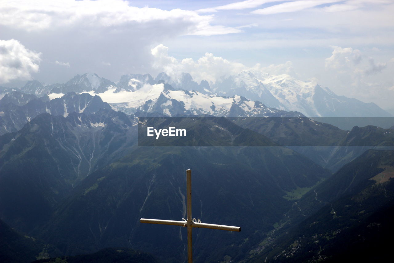 Scenic view of rocky mountains against sky from the summit with a cross