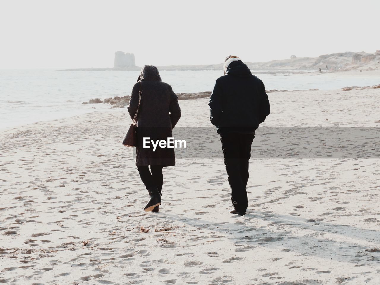 Rear view of people walking t beach