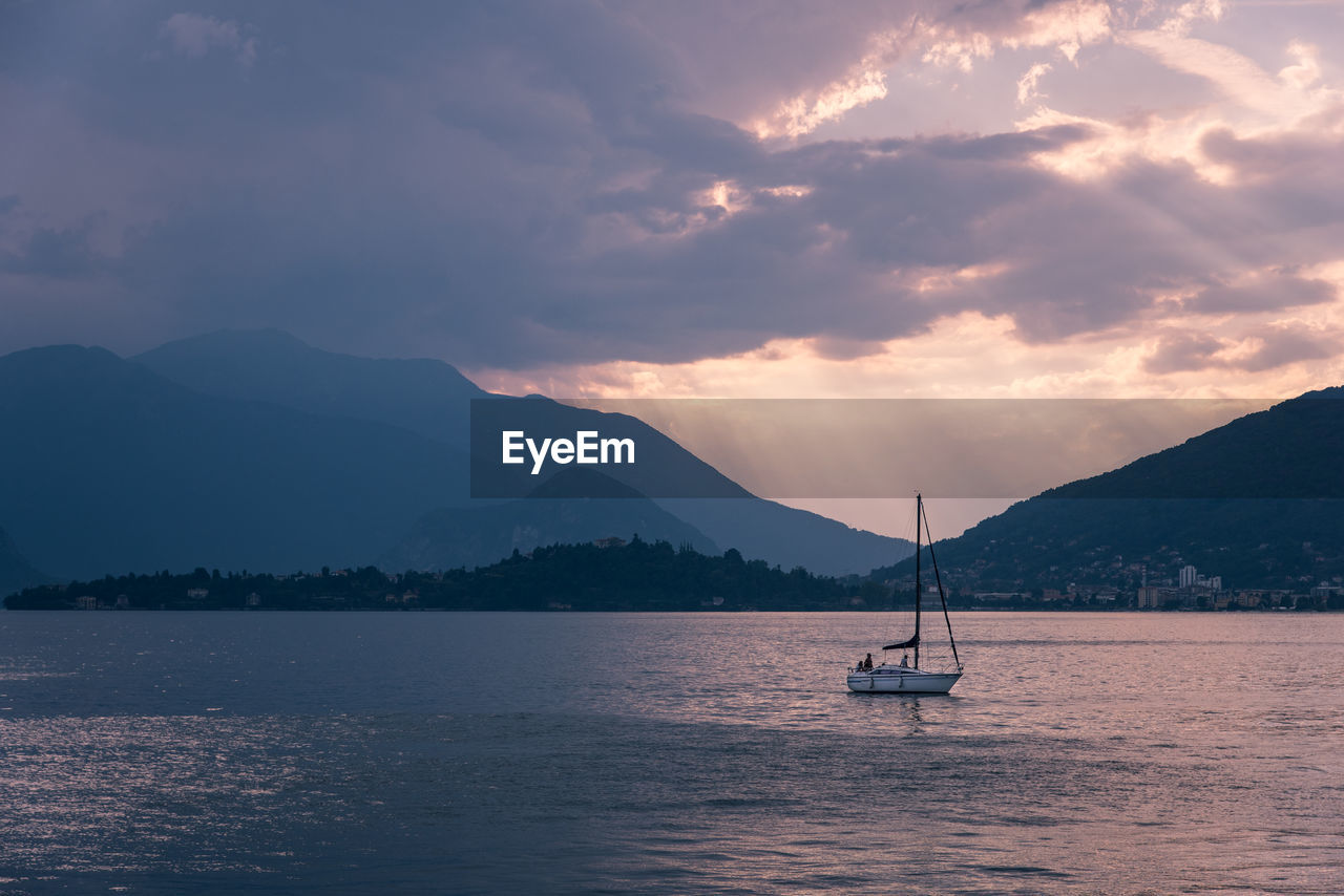 SCENIC VIEW OF SEA AGAINST MOUNTAINS