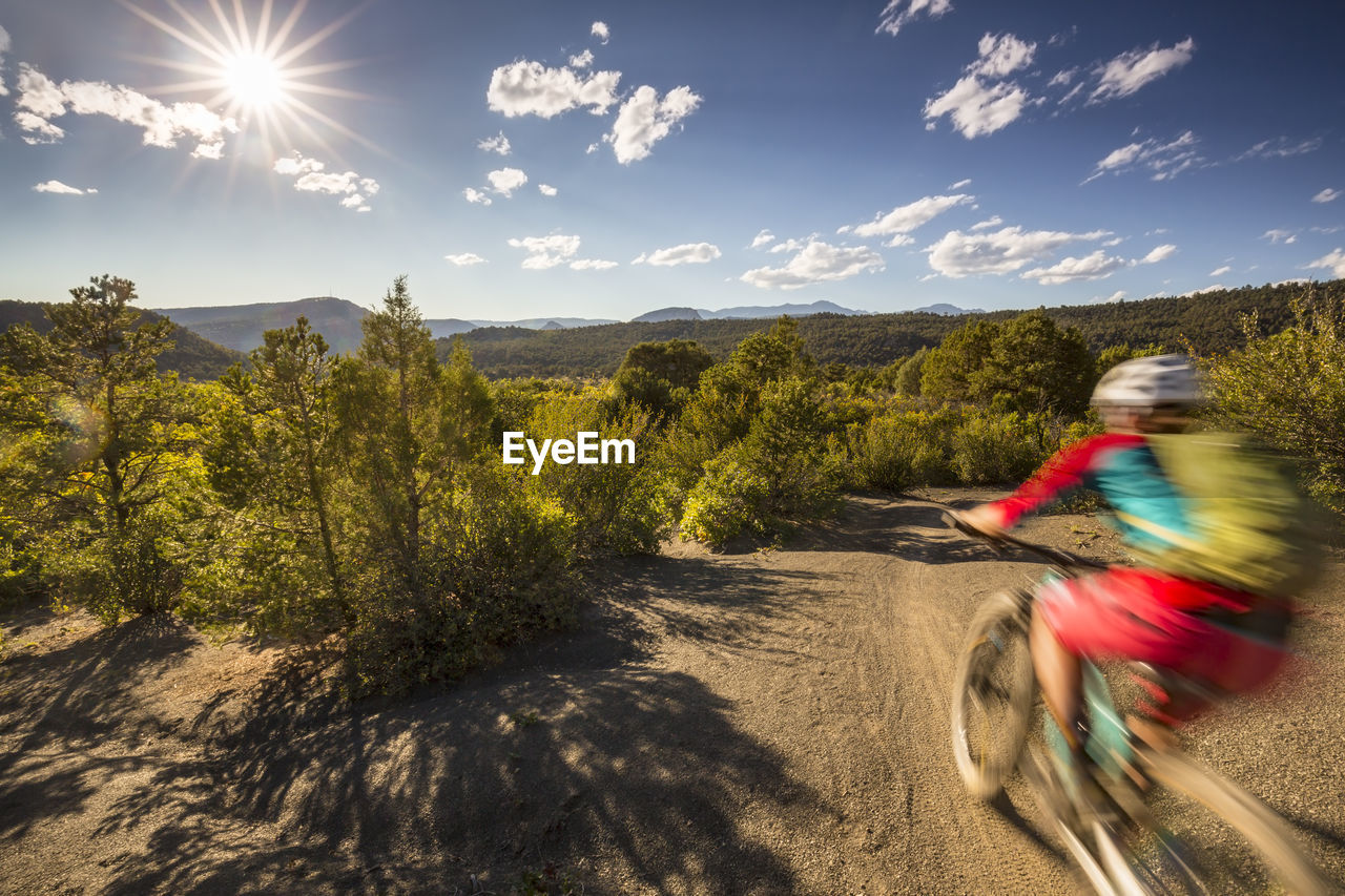 Mountain biker with motion blur riding on a trail in the mountains.