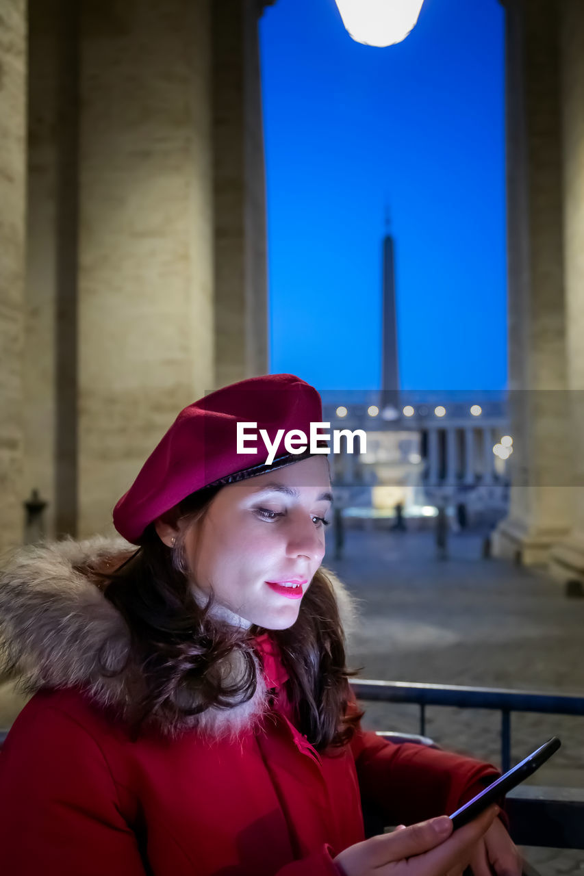 Girl in red dress looks at her smartphone