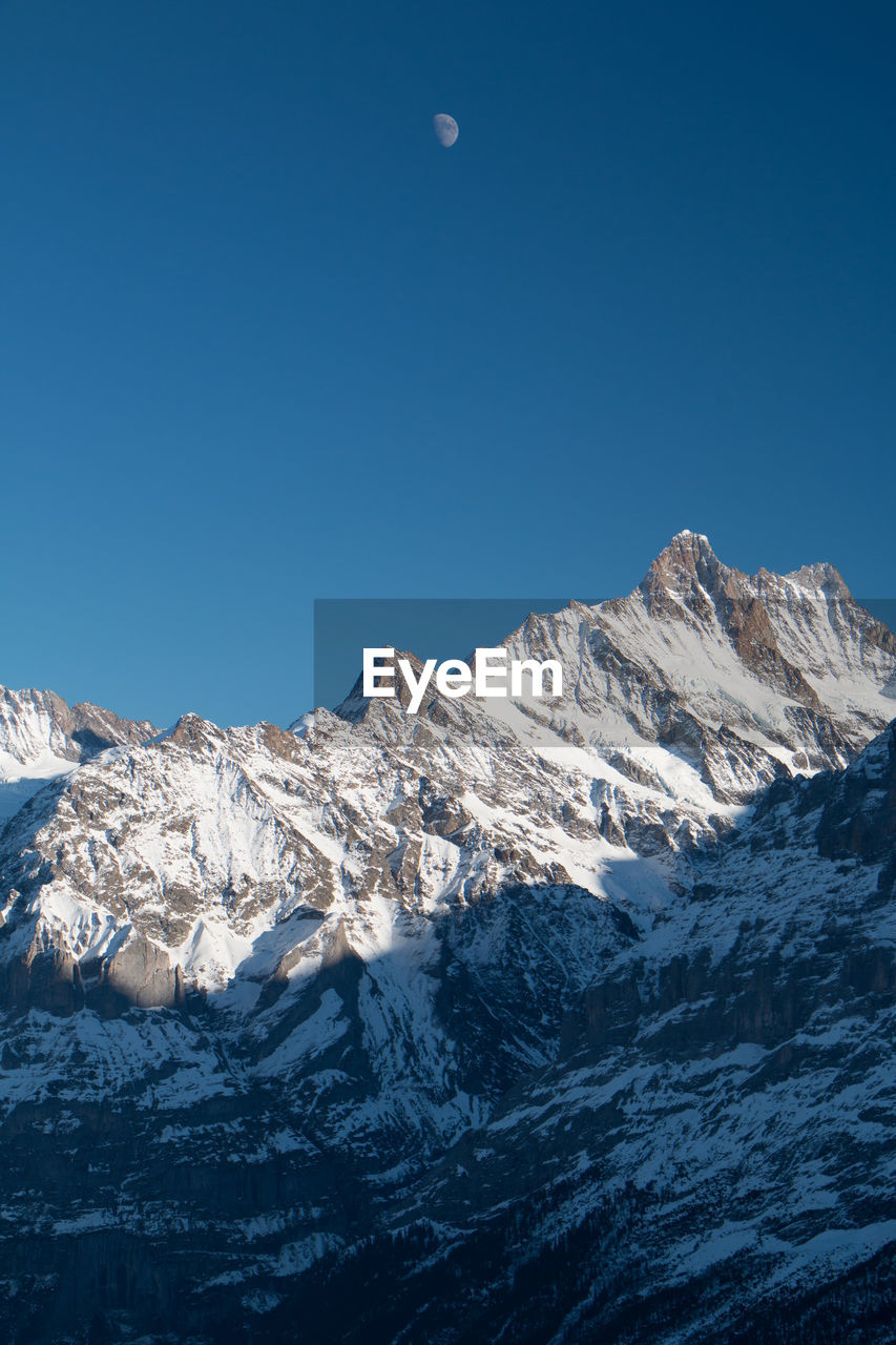 Scenic view of snow covered mountains against clear sky