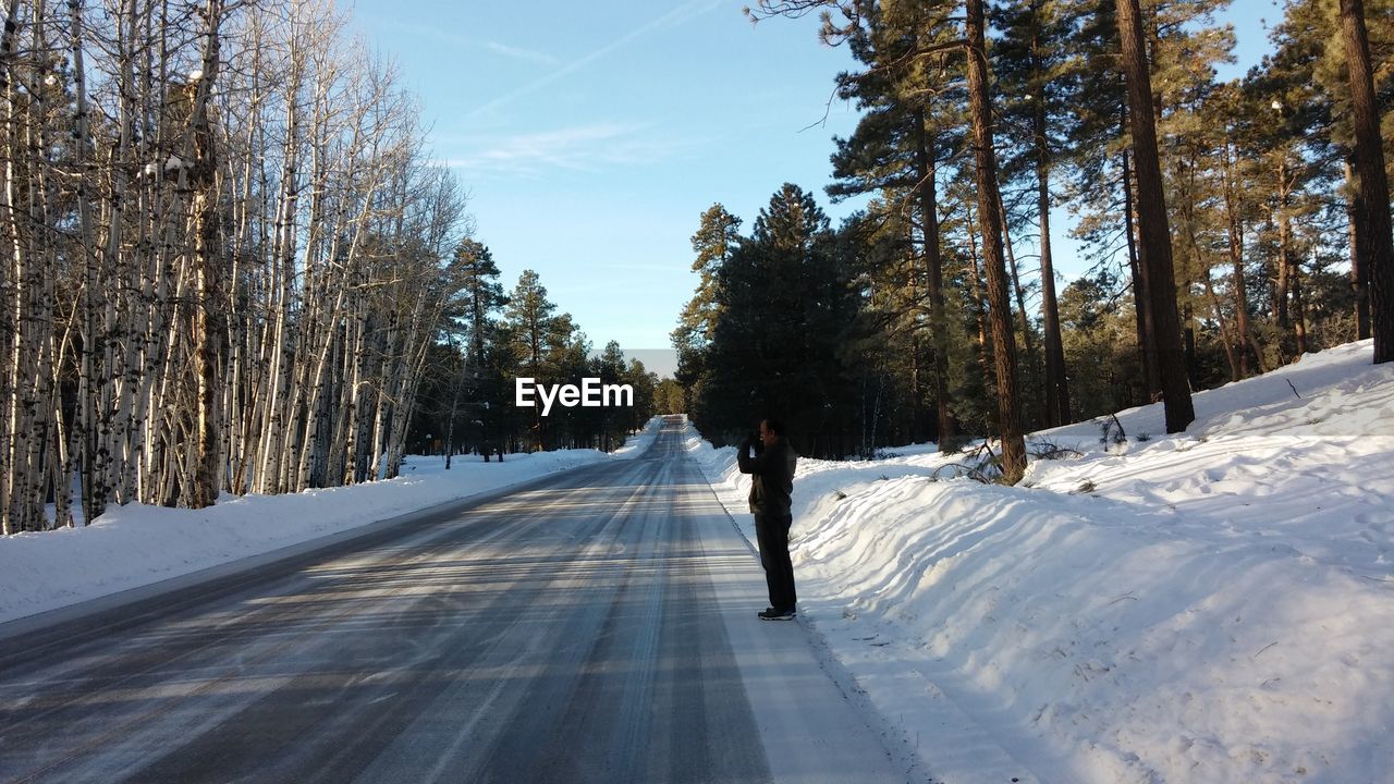 Full length of man standing on road during winter