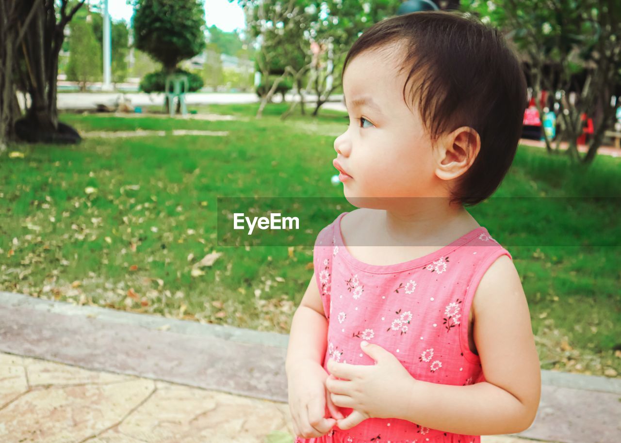 Cute little girl standing in the garden watching the sunset. portrait girl.