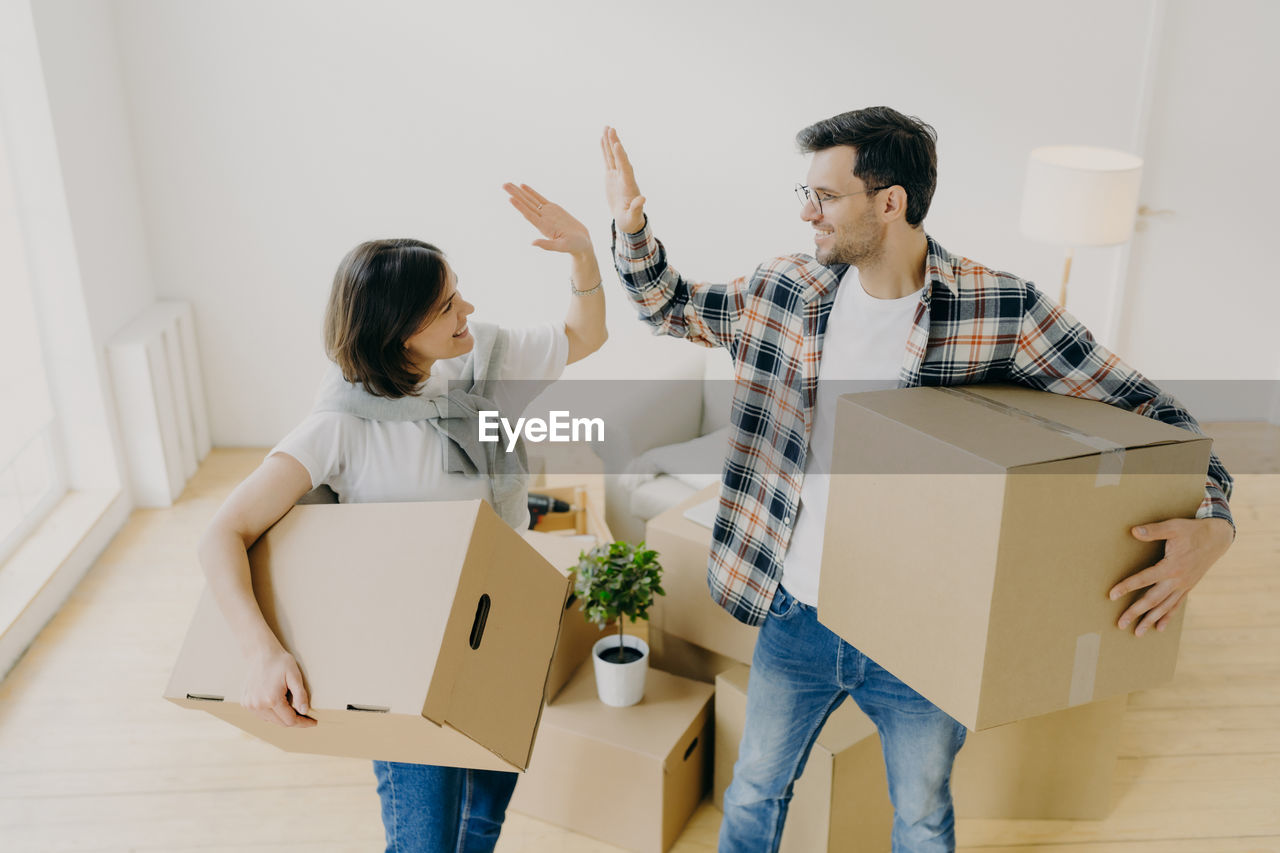 Couple holding boxes on home