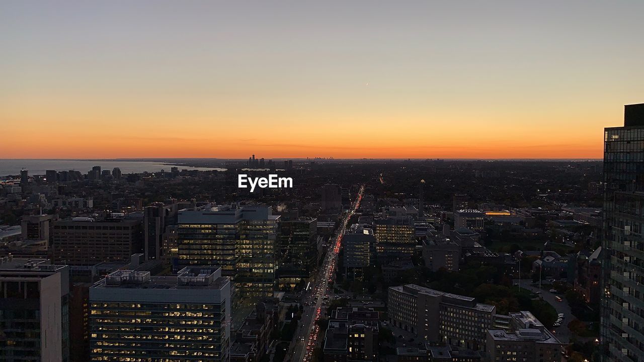 Aerial view of modern buildings against sky during sunset