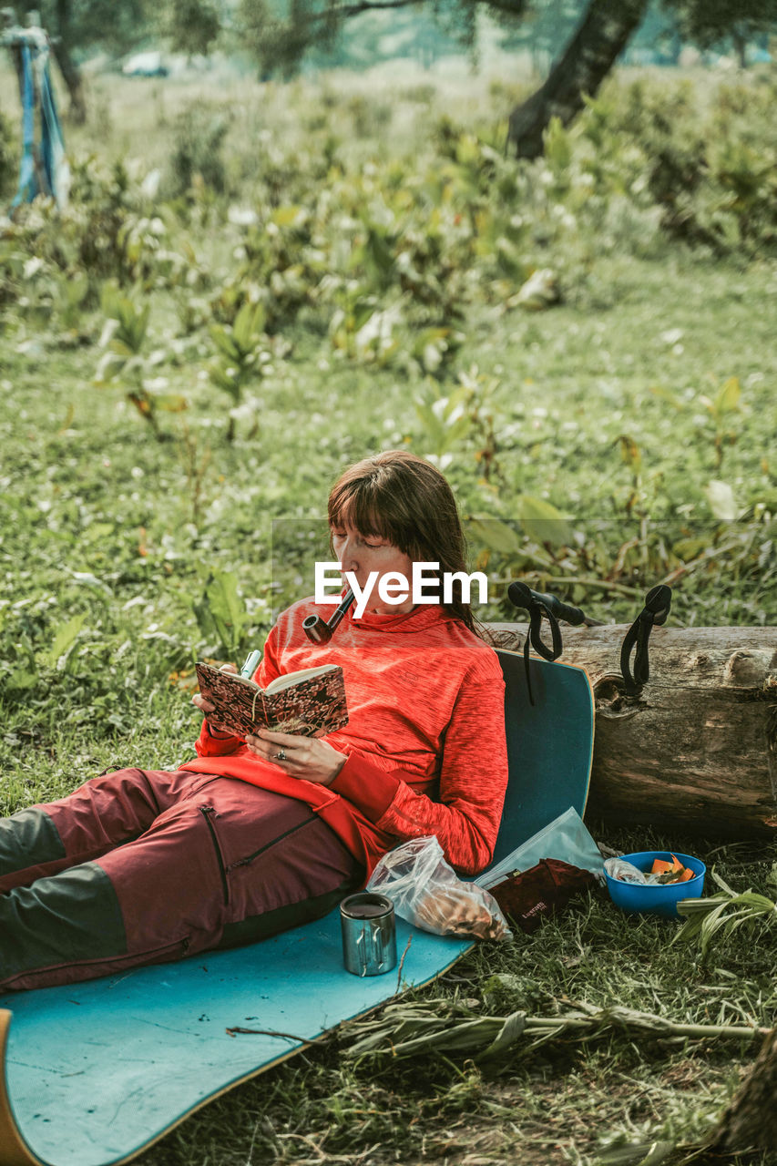 Rear view of woman sitting on field