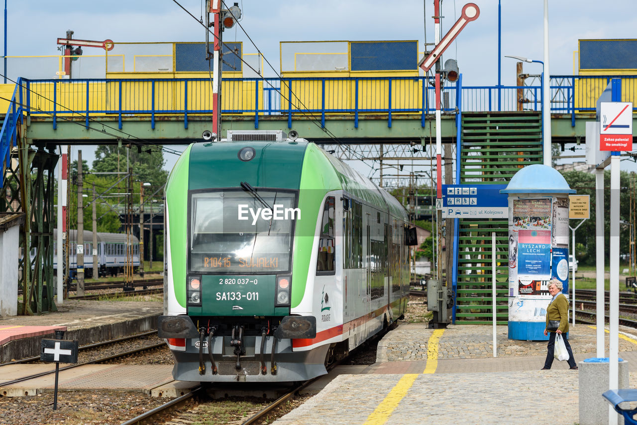 Man standing by train at railroad station