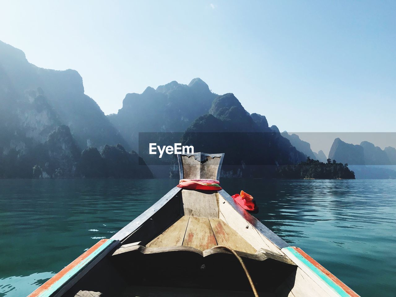 Boat moored on lake against mountain range